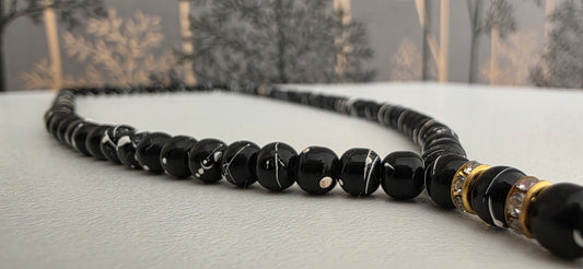 Close-up of 5mm wooden tasbih beads in matte black finish