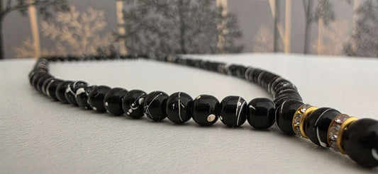 Close-up of 5mm wooden tasbih beads in matte black finish